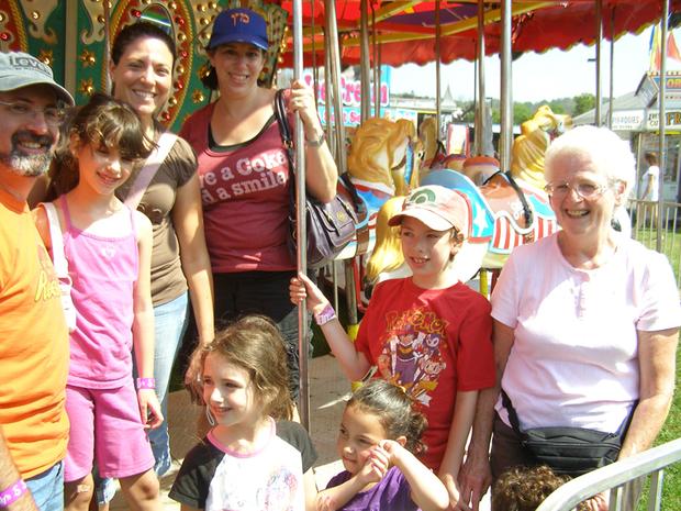 A family enjoys the carousel at the GDS Greene Dreher Sterling Fair in Newfoundland Wayne County Pennsylvania in the Pocono Mountains